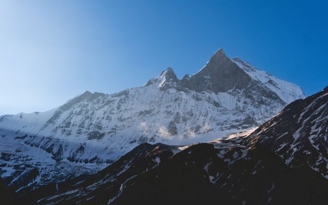 Breathtaking sunrise view of Machapuchare peak in the Himalayas, Nepal, with snow-covered slopes.