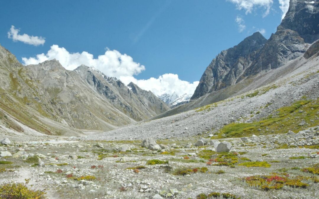 Explore the breathtaking rocky terrain and majestic peaks of the Himalayan valley under a bright blue sky.